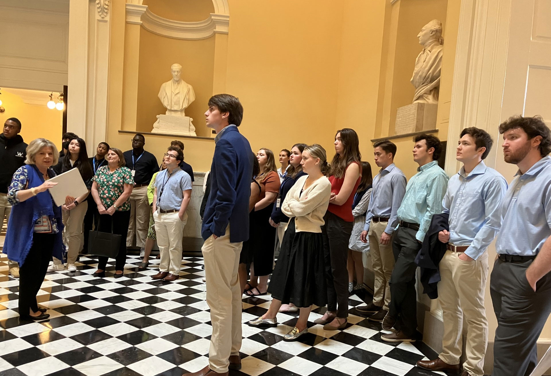 Isang grupo ng mga tao na nakatayo sa harap ng isang rebulto